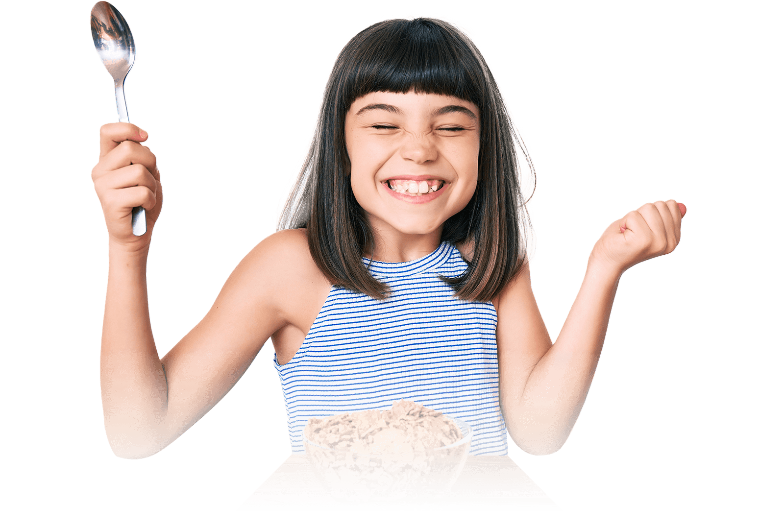 Smiling girl holding up a spoon while sitting in front of a bowl of cereal.
